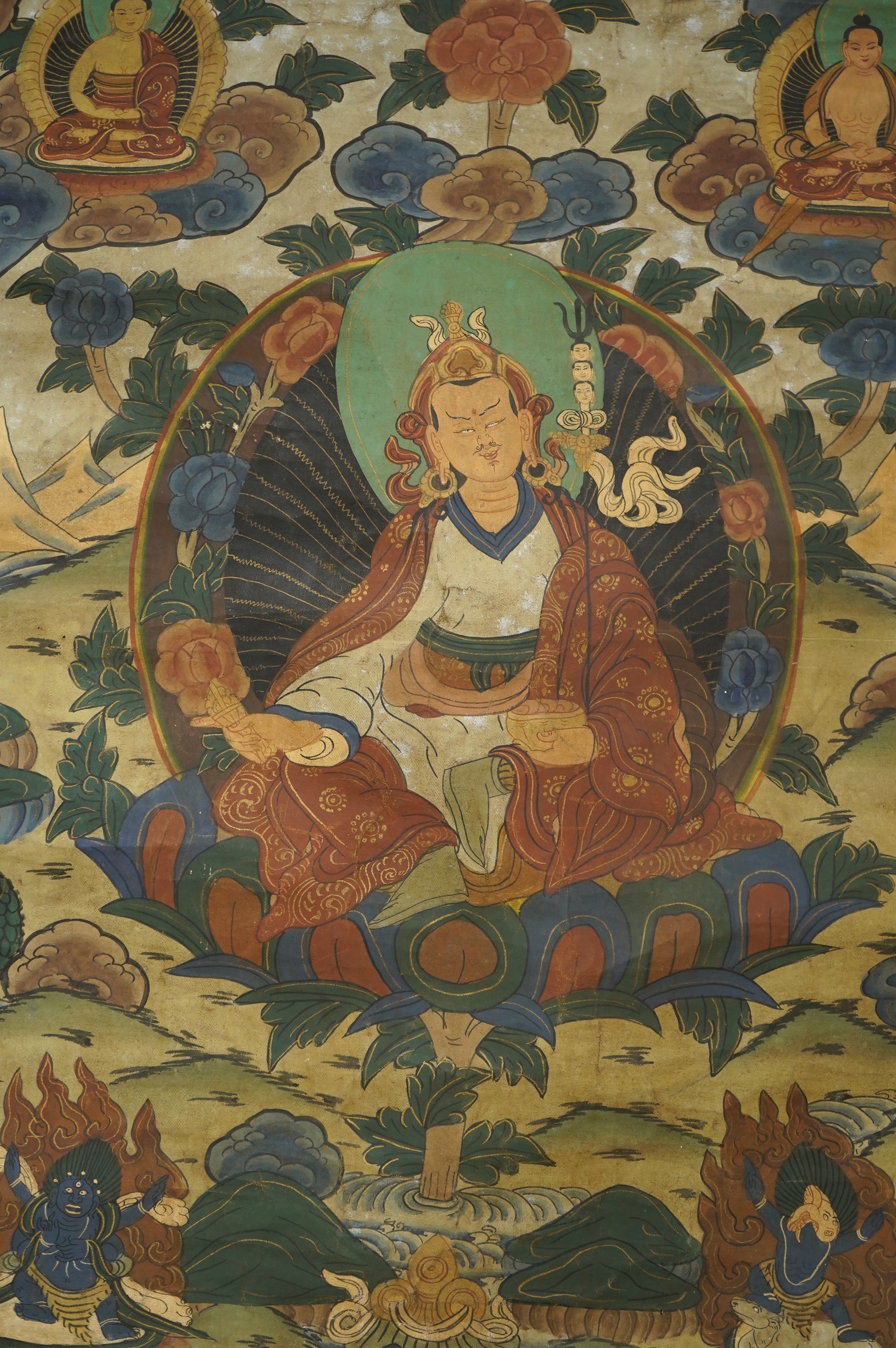 A Tibetan painted silk thangka, depicting Padmadambhara seated on a throne of lotus petals, 19th century